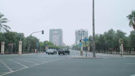 Slow-Motion,-Cars-at-intersection-in-downtown-Seville,-Spain,-on-grey-morning
