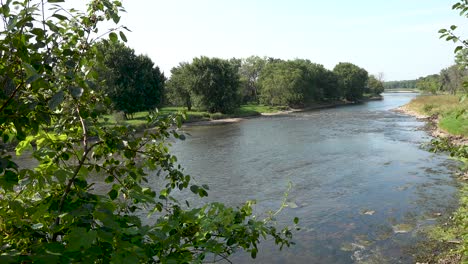 panning-shot-of-flowing-river-under-blue-morning-sky-in-wetlands-4k