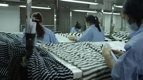 Slow-motion-shot-of-female-factory-workers-doing-quality-check-of-textile-samples-in-a-factory-in-China