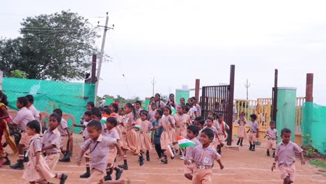 Group-of-Cheeful-smiling-Elementry-school-children-running-inside-the-school-with-the-Indian-flags-in-hands-during-Independence-day-of-India