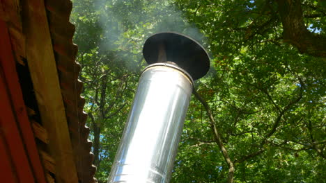 Heat-Fumes-Coming-out-of-Metal-Pipe-on-Sauna-Roof,-Sweden