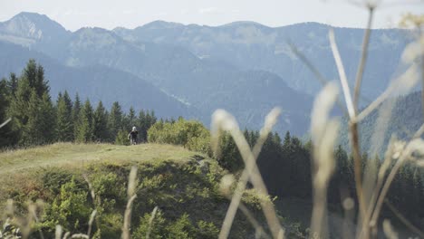 Mountainbiker-Radelt-Einen-Bergrücken-Hinauf-Und-Hält-Dann-An-Einer-Klippe-In-Den-Alpen-An