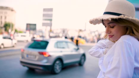 Slow-Motion:Young-beautiful-girl-stands-by-busy-road-with-traffic-on-background