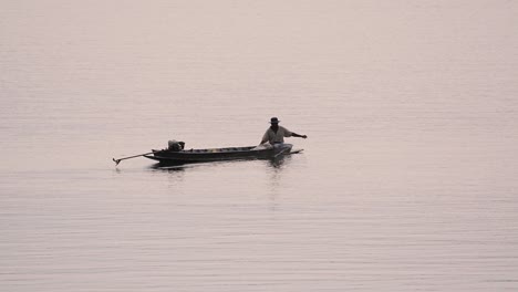 Pescador-Perfilando-Mientras-Lanza-Y-Saca-Su-Red-En-El-Río-Antes-Del-Anochecer,-En-Cámara-Lenta
