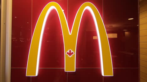 Editorial,-close-up-view-of-colorful-McDonald's-logo-on-red-wall,-beside-the-entrance-hall,-doorway-of-the-fast-food-restaurant