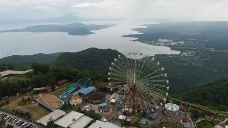Aerial-drone-view-of-Theme-park,-big-sky-eye-ferris-wheel-and-other-adventure-ride-at-the-top-of-the-mountain
