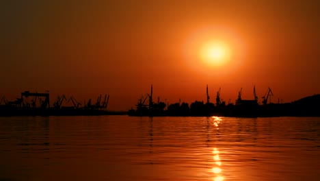 Wunderschöner-Orangefarbener-Himmel-Mit-Großer-Sonne-Bei-Sonnenuntergang-Mit-Blick-Auf-Den-Hafen