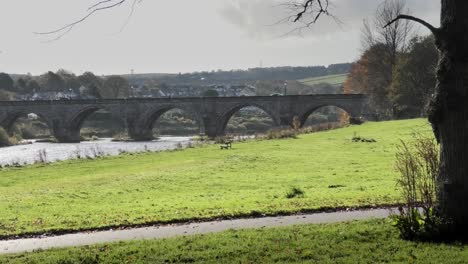 Old-Bridge-of-Dee-Aberdeen-with-woman-wearing-rucksack-walking-past-towards-the-bridge