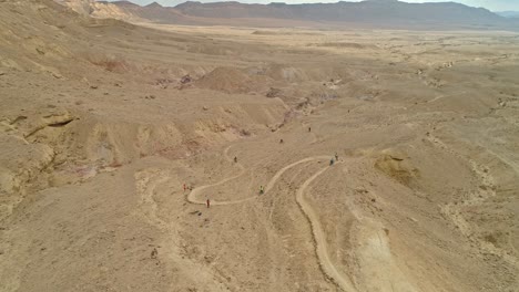 Luftaufnahmen-Einer-Gruppe-Von-Radfahrern,-Die-Auf-Radwegen-In-Den-Wüstenklippen-Unterwegs-Sind