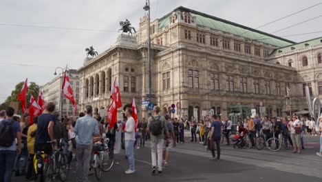 Protestors-walking-in-front-of-Opera-facade-during-fridays-for-future-climate-change-protests-in-Vienna,-Austria