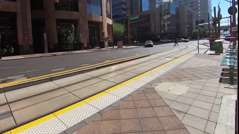 Time-lapse-automobile-traffic-races-by-the-light-rail-tracks-and-station-at-Washington-and-Central-Phoenix,-Arizona