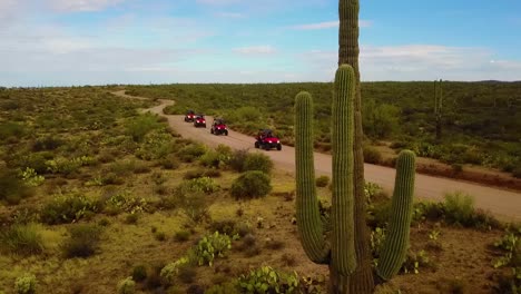 Aerial-drone-shot-that-pans-with-some-UTV's-cruising-through-the-Arizona-Desert-on-a-cloudy-day