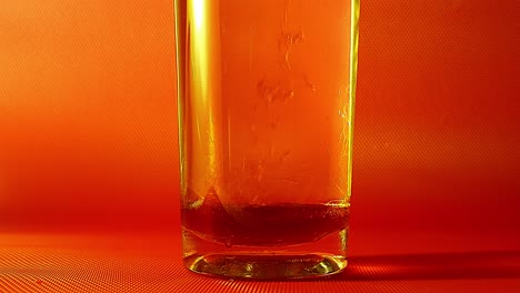 Honigtropfen-In-Einem-Glas-Wasser-Mit-Goldener-Hintergrundbeleuchtung