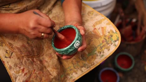 craftswoman-painting-small-pot-hands-close-up