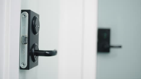 Slow-dolly-in-towards-black-modern-door-handle-on-glassdoor-in-focus