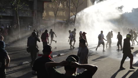 Armored-riot-police-vehicle-uses-fire-hose-to-spray-water-and-scatter-rioters
