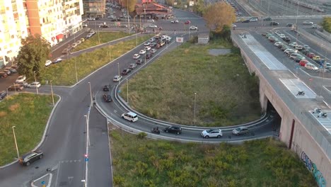 Heavy-traffic-on-a-crossroad-in-golden-hour,-moving-up-drone