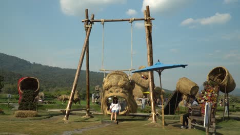 Spaß-Auf-Einer-King-Kong-Kopfschaukel-Im-Strohskulpturenpark-In-Chiang-Mai,-Thailand,-Umgeben-Von-Einer-Wunderschönen-Landschaft-Und-üppig-Grünen-Bergen