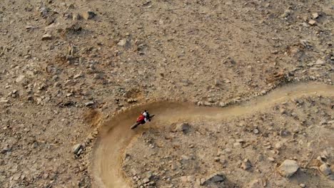 Adult-male-mountain-biker-riding-downhill-enduro-in-the-Al-Taween-mountain-biking-trail-of-Fujairah,-United-Arab-Emirates