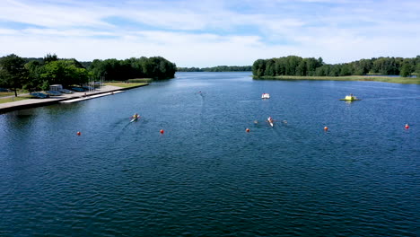 AERIAL:-Following-Shot-of-Kayaking-Athletes-in-Paddling-Canoes-on-the-Surface-of-the-Lake-Racing-Towards