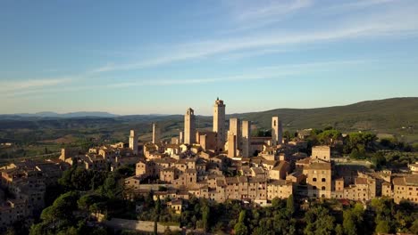 San-Gimignano-town-in-Tuscany-Italy-panorama-of-the-tower-structures-including-Torre-Grossa,-Aerial-drone-orbit-reveal-shot