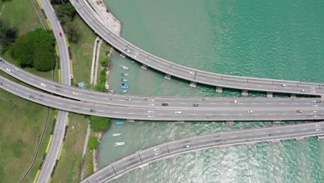 Top-aerial-view-of-Penang-Bridge-Malaysia-with-the-first-segment-from-the-island-seen-with-lite-traffic,-drone-dolly-lift-shot