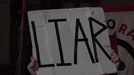 Ein-Demonstrant-Hält-Ein-Weißes-Plakat-Hoch,-Auf-Dem-In-Schwarzer-Schrift-„Lügner“-Steht,-Um-Gegen-Premierminister-Boris-Johnson-Zu-Protestieren