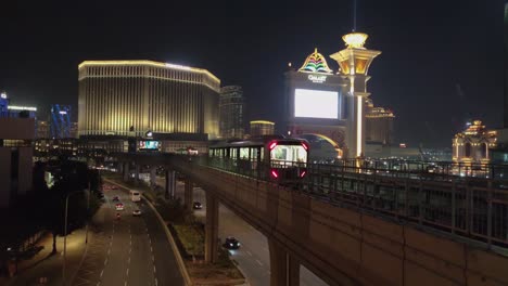 Zwei-Macau-Light-Rapid-Transit-Züge-Fahren-Vor-Den-Hotels-Venetian-Und-Galaxy-Aneinander-Vorbei