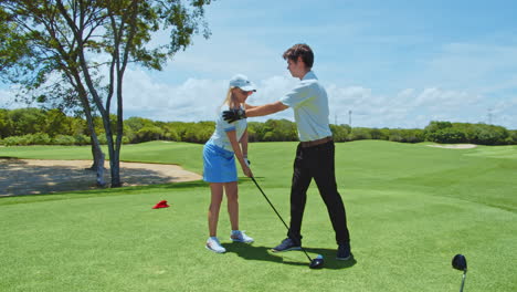 Slow-Motion:-Golf-Instructor-Teaching-Female-Student-Golf-Posture-and-Correct-Handling-of-Club-on-Green-Course