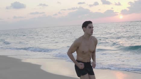 Athletic-young-runner-jogging-alone-on-beach-in-the-evening