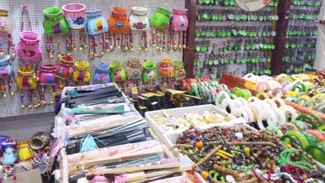 Colourful-souvenirs-including-dolls,-wicker-baskets,-bracelets,-jewellery-and-others-for-sale-for-sale-in-souvenir-shops-in-Ci-Qi-Kou-Old-town,-Chongqing,-China