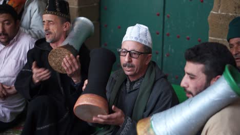 Closeup-of-men-in-traditional-clothing-chanting-and-hitting-drums-going-into-a-trance-during-a-Sufi-ceremony