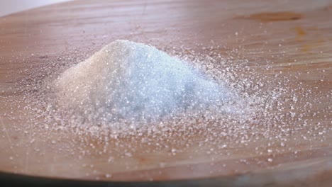 Haufen-Weißer-Zucker,-Der-Auf-Einem-Holzbrett-Rotiert