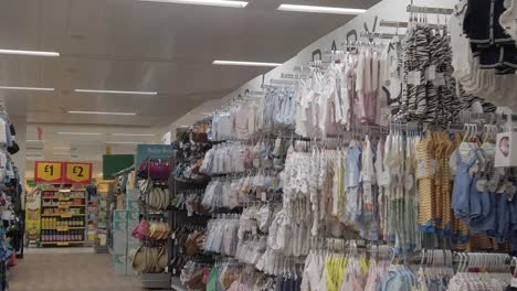 Slow-motion-interior-empty-UK-supermarket-passing-closed-baby-clothes-aisle