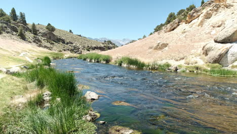 Coursing-River-Flowing-Through-Inyo-National-Forest-at-Hot-Creek-Geological-Site,-Blue-Sky-and-Sunshine
