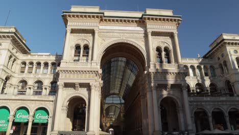 Galleria-Vittorio-Emanuele-Ii-Entrada-Principal-Del-Arco-Triunfal-Desde-La-Piazza-Duomo,-Toma-De-órbita-Amplia-Durante-Un-Día-Soleado