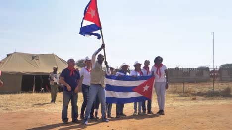 Afrikanischer-Mann,-Der-Bei-Einer-Kulturellen-Veranstaltung-In-Botswana-Die-Kubanische-Flagge-Hisst