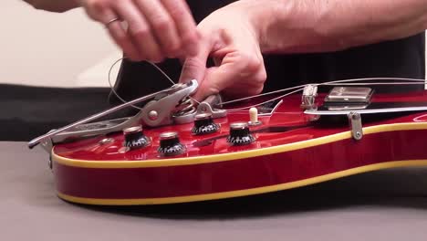 Putting-new-guitar-string-through-the-guitar-bridge