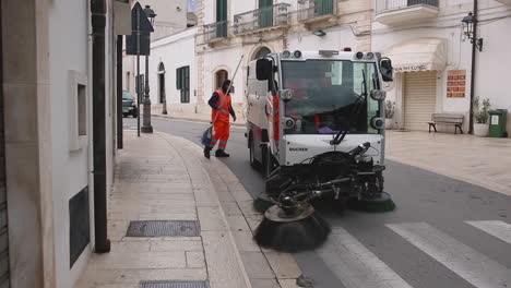 Sweeping-machine-on-the-street-cleaning-and-two-workers-with-brooms