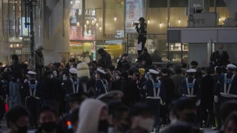 Uniformed-Cops-Roving-Around-Controlling-The-Massive-Crowd-On-Halloween-Night-2020-At-Shibuya-Crossing-In-Tokyo,-Japan---Slow-Motion