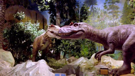 Dinosaur-Jurassic-animatronic-exhibit-at-Sunworld-Amusement-park-with-Allosaurus-and-T-Rex-models,-Pan-left-handheld-shot