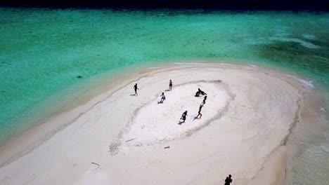 Nusa-word-formed-by-people-meaning-island-in-the-Indonesian-language-on-a-tiny-reef-isle,-Aerial-dolly-out-shot