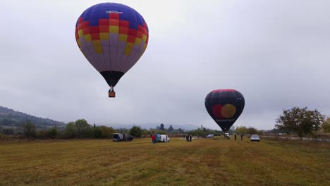 Colorful-hot-air-balloon-rises-up-slowly-into-the-air,-cloudy-sky