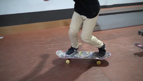 Skateboarder-Macht-Stunt-Und-Rutscht-Auf-Der-Stange-In-Der-Halle-Des-Skateparks