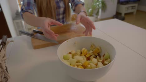 This-is-a-4k-60fps-slow-motion-shot-of-a-girl-moving-a-white-bowl-with-fruit-salad-in-it