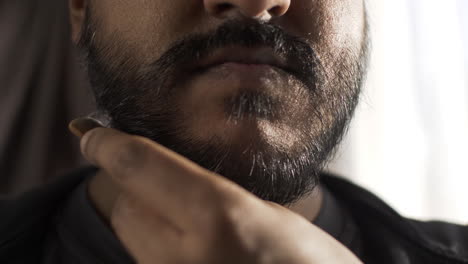 Close-Up-Of-Ethnic-Minority-Adult-Male-Combing-Beard