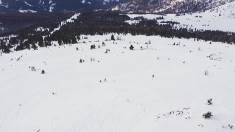 Aerial-tilt-up-of-skier-skiing-alone-on-the-empty-snow-covered-piste-during-covid-19-pandemic