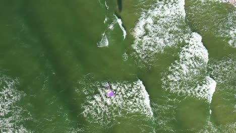 AERIAL:-Top-View-Shot-of-One-Surfer-Riding-Big-Waves-and-Engaged-in-Extreme-Sports