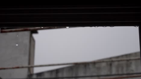 Slow-motion-clip-of-raindrops-falling-off-a-window-pane