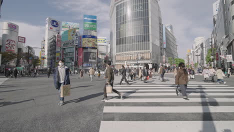 Hyperlapse-Von-Japanern-Am-Shibuya-Kreuzung-An-Einem-Geschäftigen,-Sonnigen-Tag-Während-Der-Pandemie-In-Tokio-–-Aufnahme-Aus-Niedriger-Höhe
